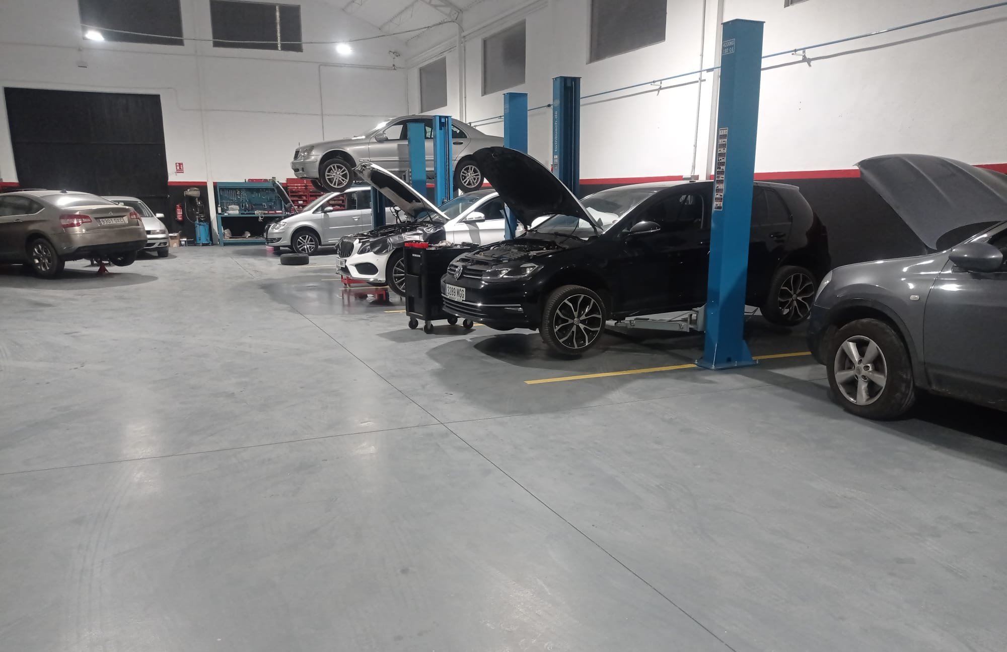 Interior del taller con varios coches en reparación